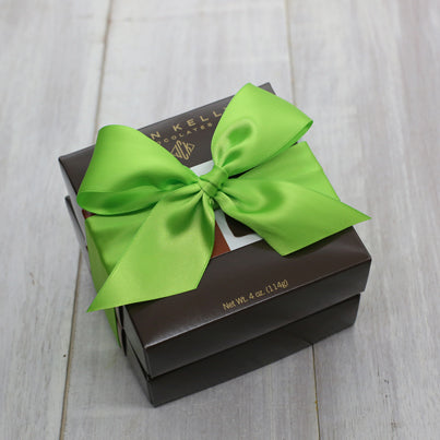 Two boxes stacked. They are tied together with a green ribbon.