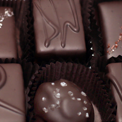 A close up of some of our chocolate pieces in brown, paper cups.