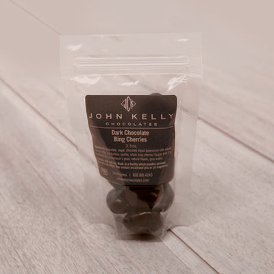 The chocolate covered cherries sit in a plastic bag. A dark brown label is on front of the bag.