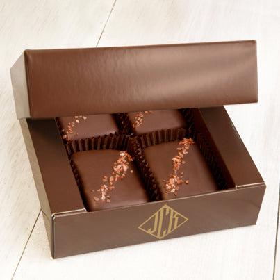 Four pieces of red salted chocolate in a brown box.