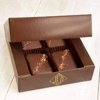 Four pieces of red salted chocolate in a brown box.