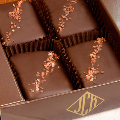 Four pieces of red salted chocolate in a brown box.