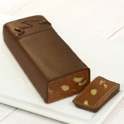 A long rectangular chocolate bar with a CW on it that signifies it is semi-sweet with walnuts. One end of the bar is cut to reveal the chocolate and walnuts inside.