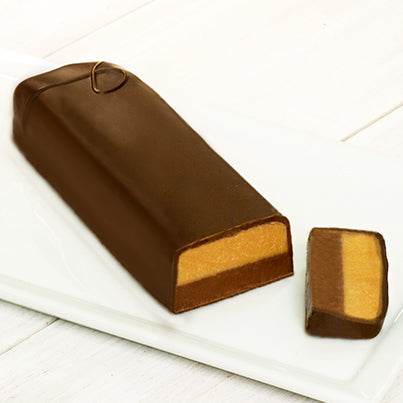 A long chocolate bar with a P on it to signify it is a semi-sweet chocolate bar with peanut butter. A sliver at the end of the chocolate bar is cut off to reveal the chocolate and peanut butter inside.