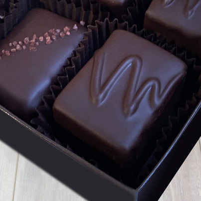 A close up of the white chocolate vanilla with walnuts from the 6 piece assortment box. The chocolate reads VW for vanilla with walnuts