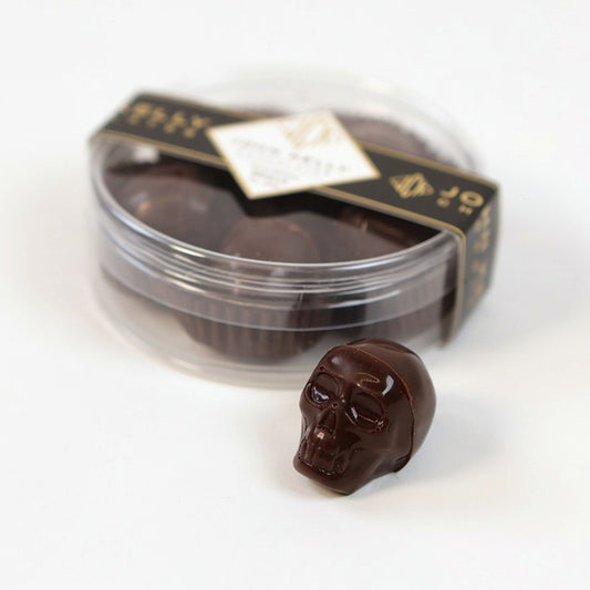 5-Piece Dark Chocolate Skulls with Spiced Chocolate Caramel Filling, closed box with one skull in front