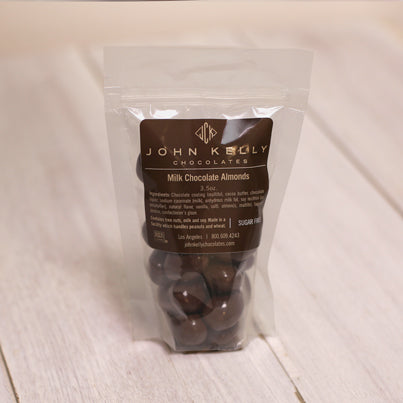 A bag of milk chocolate almonds sits waiting to be eaten.