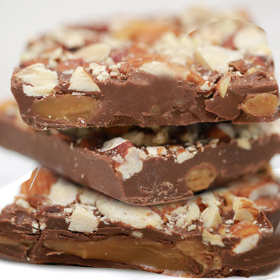 Three bars of the milk chocolate bark sit stacked vertically. They are filled with almonds and caramel.