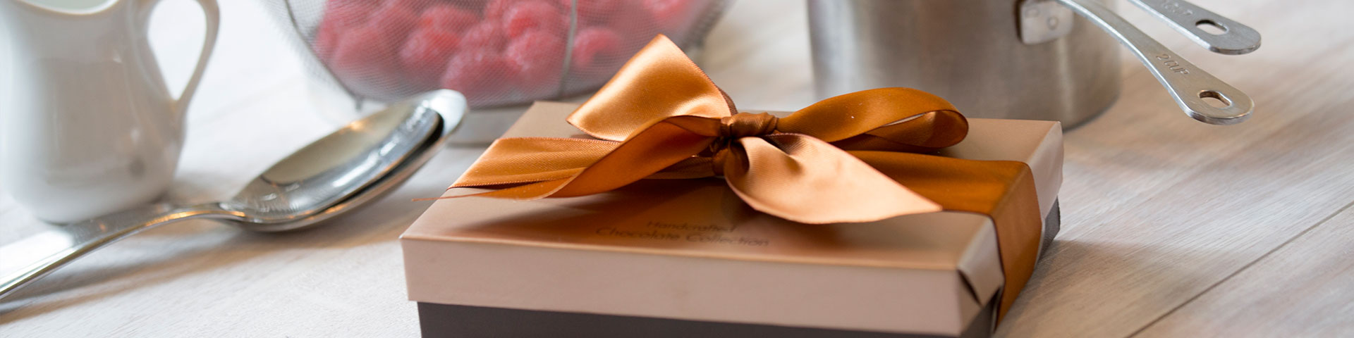 A brown gift box with a gold ribbon.