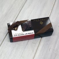 A rectangular, dark brown box with a white dark chocolate with walnuts sleeve on it. The box has a brown ribbon on it.