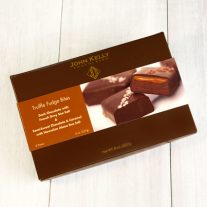A dark brown box with a sleeve on it. The left half of the sleeve is brown while the right is white with a picture of salted chocolates on it.