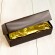 A gold wrapped long, rectangular bar sit in a dark brown box.