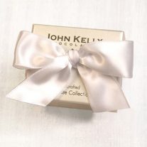 A cream colored small box. The box is tied closed with a white bow.