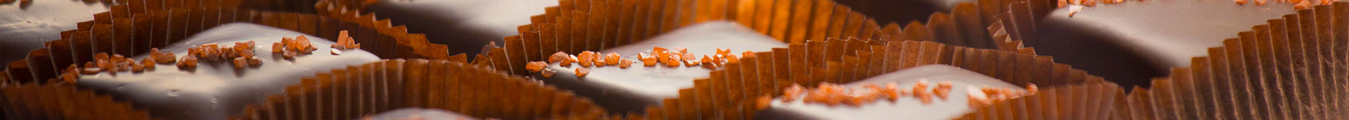 Salted chocolate sitting neatly in brown, paper cups.