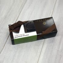 A rectangular, dark brown box with a white semi-sweet chocolate sleeve on it. The box has a brown ribbon on it.