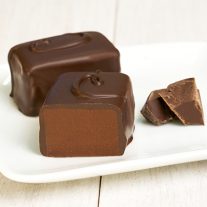 A semi-sweet chocolate bar. There is two in the picture and one is cut in half. The letter C can be seen on the top of the bars.