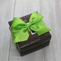 Two boxes stacked. They are tied together with a green ribbon.