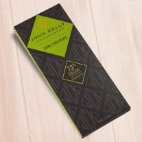 A dark brown, rectangular box. There is a green diamond on it that holds a John Kelly Chocolates logo and the product name.