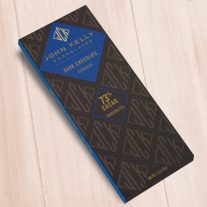 A dark brown, rectangular box. There is a blue diamond on it that holds a John Kelly Chocolates logo and the product name.