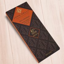 A dark brown, rectangular box. There is an orange diamond on it that holds a John Kelly Chocolates logo and the product name.