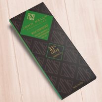 A dark brown, rectangular box. There is a dark green diamond on it that holds a John Kelly Chocolates logo and the product name.