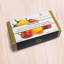 A gold box with a sleeve on it that has chilis on it. The white is mostly white with a label on it with the product name.