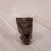 The chocolate covered cherries sit in a plastic bag. A dark brown label is on front of the bag.