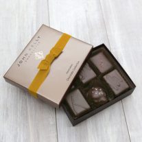 An open 6 piece assortment with a gold ribbon