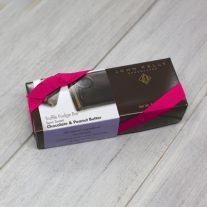 A semi-sweet chocolate with peanut butter 8oz bar box with a fuchsia ribbon. The box is brown and has a label on it with an image of the P on the semi-sweet chocolate with peanut butter bar.