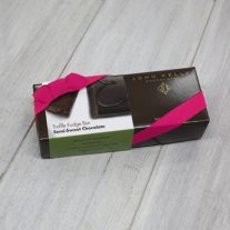 A semi-sweet chocolate 8oz bar box with a fuchsia ribbon. The box is brown and has a label on it with an image of the C on the semi-sweet bar.