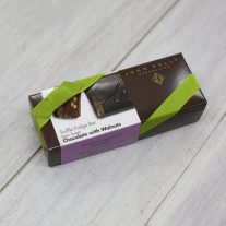 A dark brown rectangular box with a purple semi-sweet chocolate with walnuts sleeve on it. It is closed with a lime stretchy ribbon.