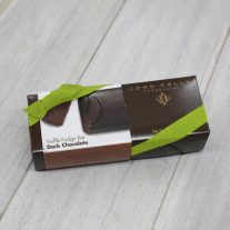 A dark brown rectangular box with a brown dark chocolate sleeve on it. It is closed with a lime stretchy ribbon.