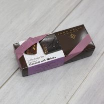 A dark brown rectangular box with a purple semi-sweet chocolate with walnuts sleeve on it. It is closed with an orchid stretchy ribbon.